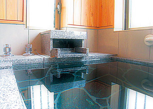 温泉を満々とたたえる、石材をあしらった趣のある浴室。